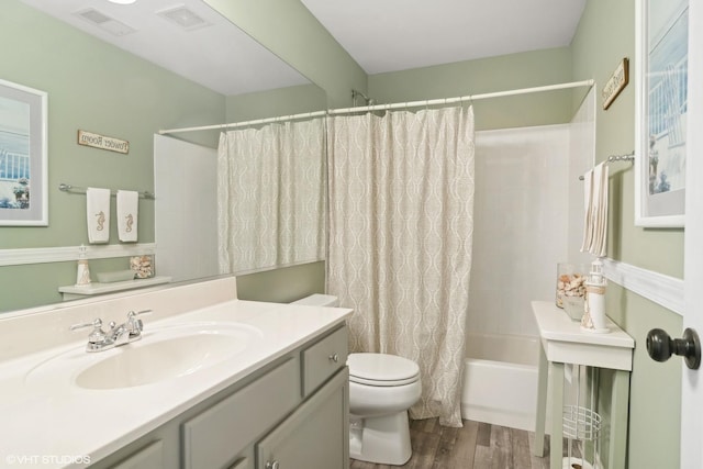 bathroom with visible vents, shower / bathtub combination with curtain, toilet, vanity, and wood finished floors