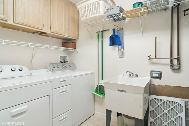 laundry room featuring a sink, washing machine and clothes dryer, and cabinet space