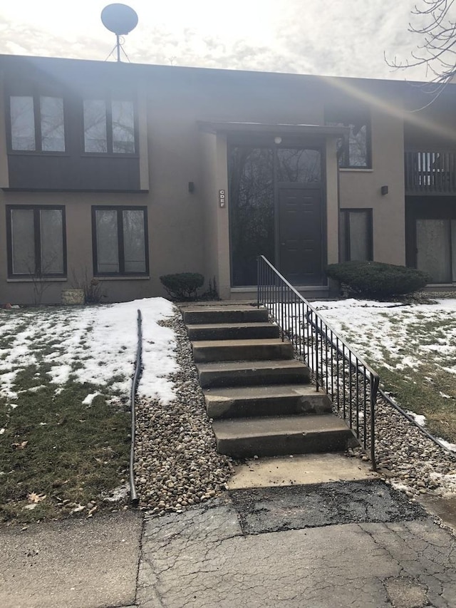 property entrance with stucco siding