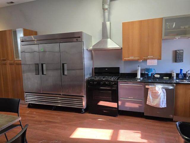 2147 W Belmont Ave, Chicago, IL 60618 - kitchen featuring dark stone counters, brown cabinets, wood finished floors, stainless steel appliances, and a sink