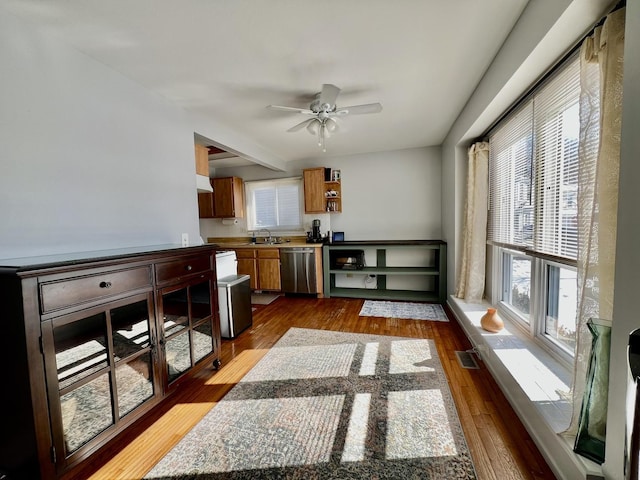 interior space with visible vents, dishwasher, dark wood-style flooring, open shelves, and a sink