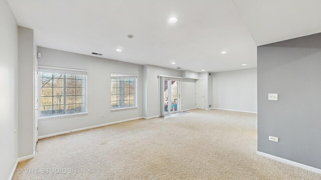 carpeted spare room featuring baseboards, visible vents, and recessed lighting