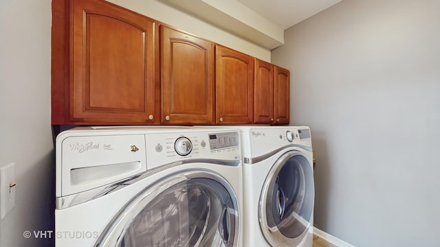 laundry area with independent washer and dryer, cabinet space, and baseboards