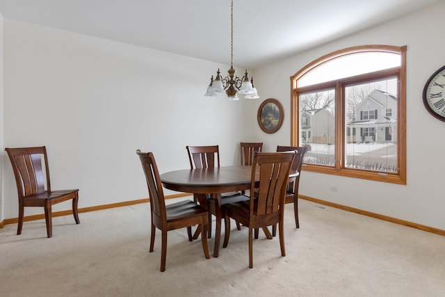 dining space featuring baseboards, a notable chandelier, and light colored carpet