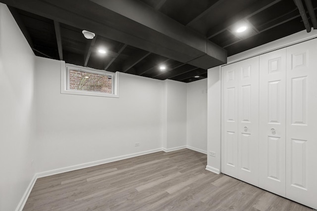 basement featuring baseboards and wood finished floors