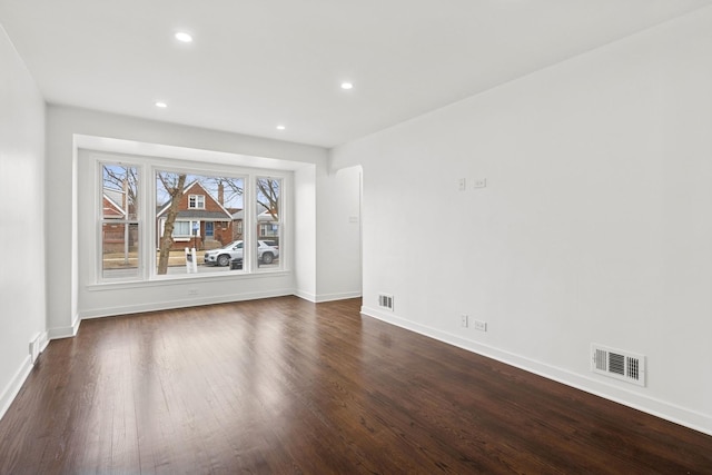 interior space featuring baseboards, visible vents, dark wood-type flooring, and recessed lighting