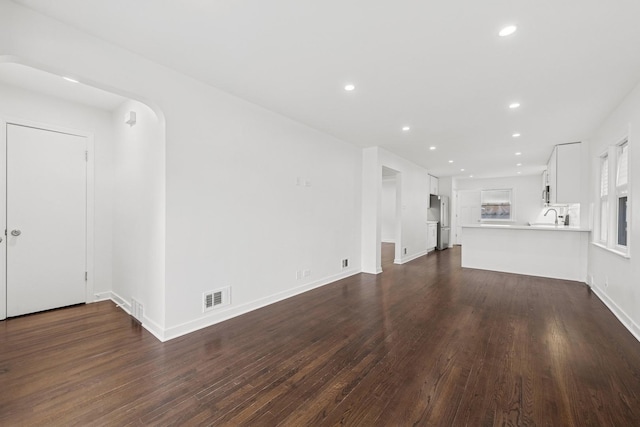 unfurnished living room featuring dark wood-style floors, visible vents, and recessed lighting