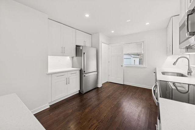 kitchen with appliances with stainless steel finishes, light countertops, and a sink