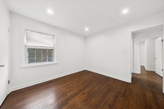 empty room with dark wood-style flooring, recessed lighting, and baseboards