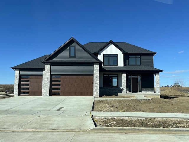 view of front of home with an attached garage, board and batten siding, a shingled roof, and concrete driveway