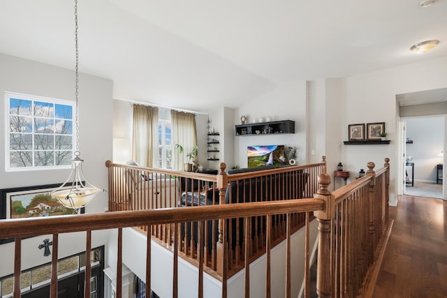 corridor featuring lofted ceiling, an upstairs landing, and wood finished floors