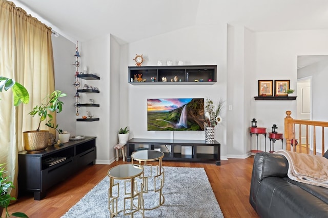 living room with lofted ceiling, baseboards, and wood finished floors