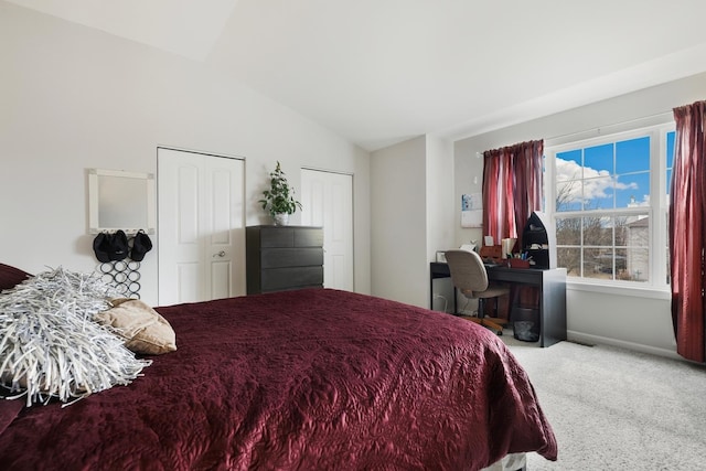 bedroom with multiple closets, lofted ceiling, baseboards, and carpet