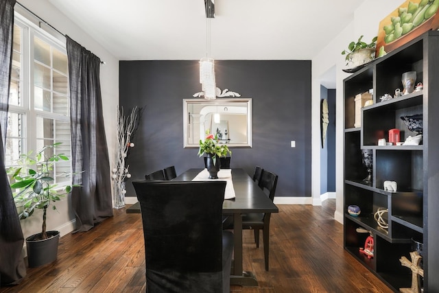 dining area featuring dark wood finished floors and baseboards