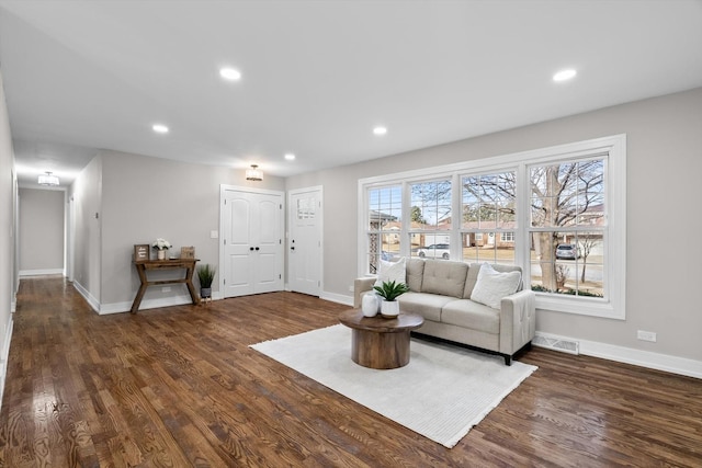 living area with dark wood-type flooring, recessed lighting, visible vents, and baseboards