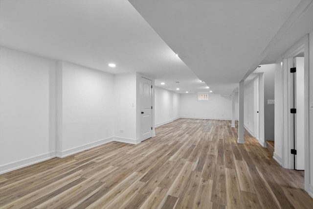 finished basement featuring light wood-type flooring, baseboards, and recessed lighting