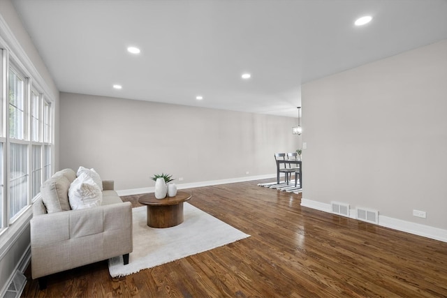 sitting room with dark wood-type flooring, recessed lighting, visible vents, and baseboards