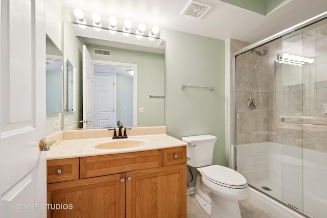 bathroom featuring toilet, a stall shower, and visible vents