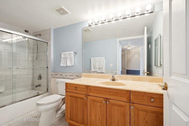 bathroom with visible vents, toilet, tile patterned flooring, combined bath / shower with glass door, and vanity