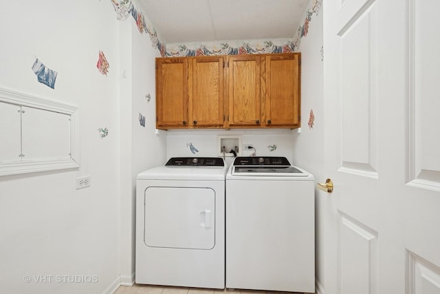 clothes washing area featuring washing machine and dryer and cabinet space