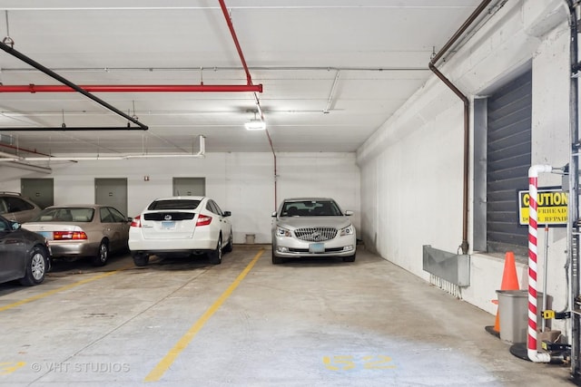 parking garage featuring electric panel and water heater