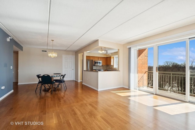 unfurnished dining area featuring a chandelier, visible vents, light wood-style floors, and baseboards