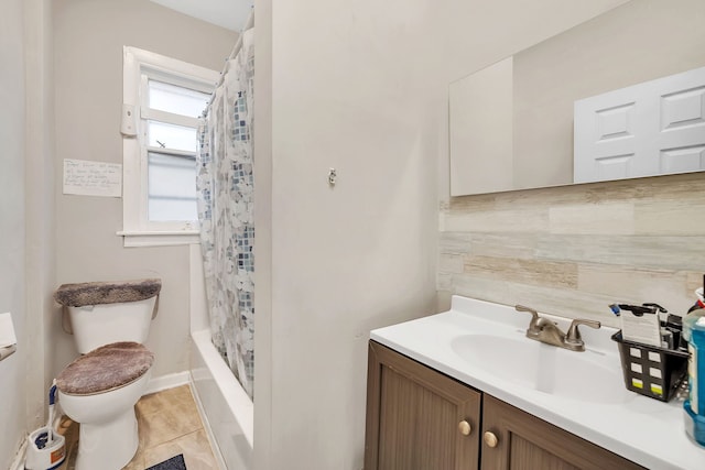 bathroom featuring tile patterned flooring, vanity, toilet, and shower / bath combo with shower curtain