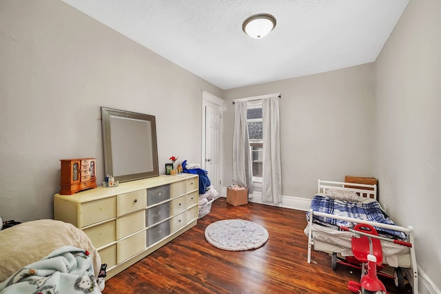 interior space with dark wood-style floors, baseboards, and a textured ceiling