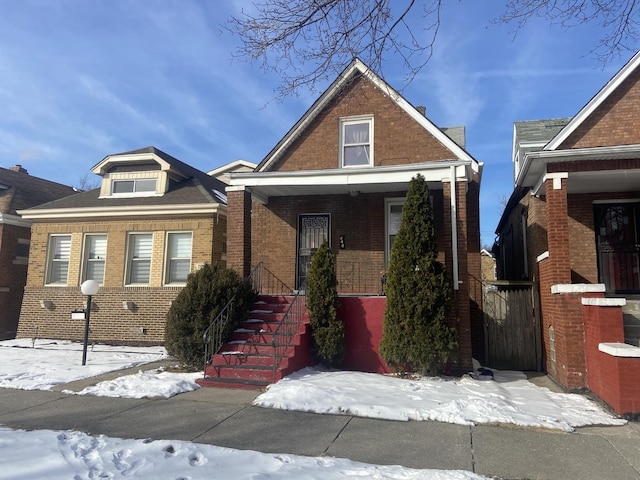 view of front of home with brick siding and a porch