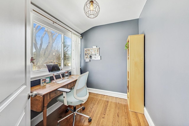 home office with lofted ceiling, light wood-style flooring, and baseboards