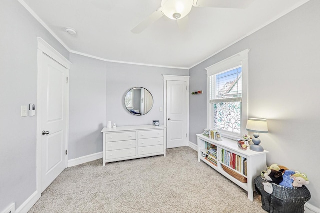 carpeted bedroom featuring ceiling fan, ornamental molding, and baseboards