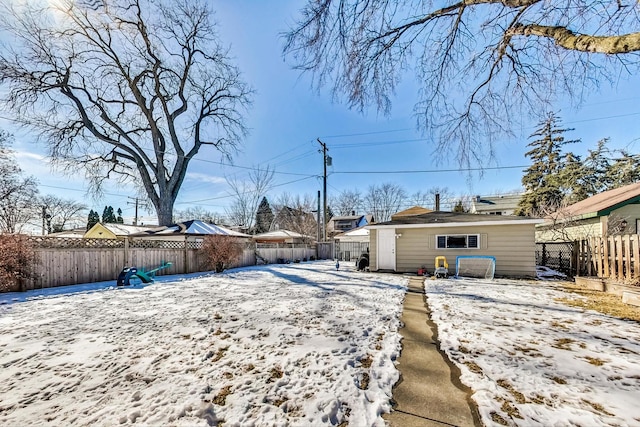 yard covered in snow featuring an outbuilding and a fenced backyard