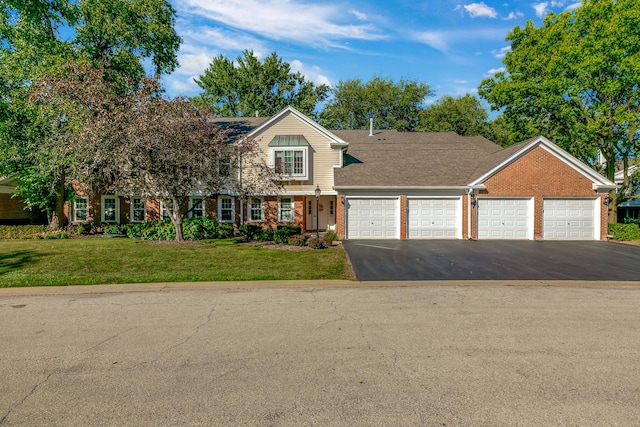 view of front facade with an attached garage, aphalt driveway, a front lawn, and brick siding