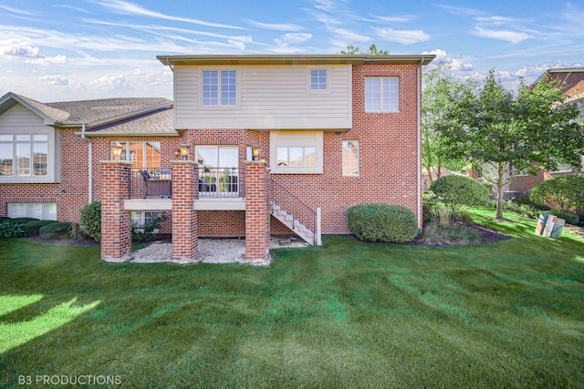 rear view of house featuring stairway, a lawn, and brick siding