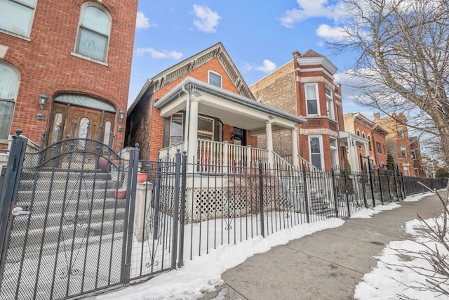 exterior space with a fenced front yard, a gate, and brick siding