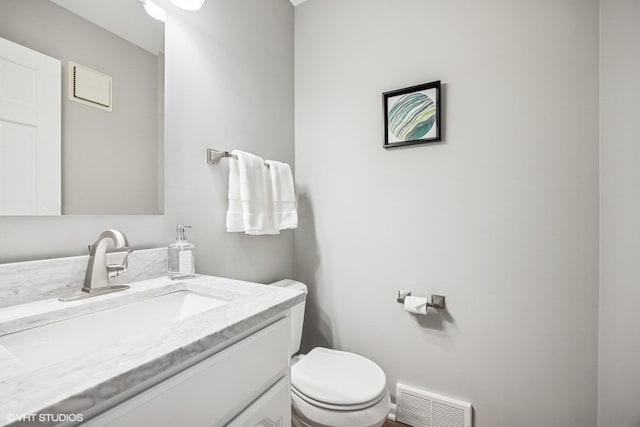 bathroom with visible vents, vanity, and toilet