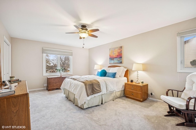 bedroom with ceiling fan, baseboards, and light colored carpet