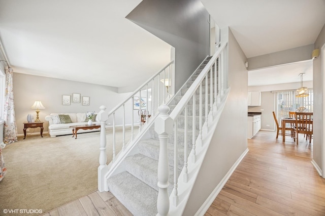 stairway featuring baseboards and wood finished floors