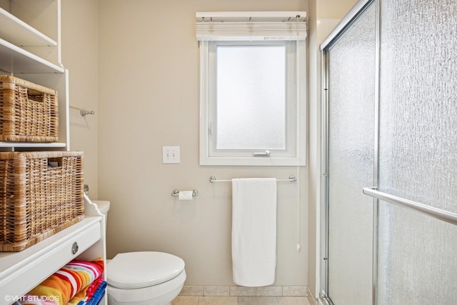 bathroom with toilet, an enclosed shower, and tile patterned floors