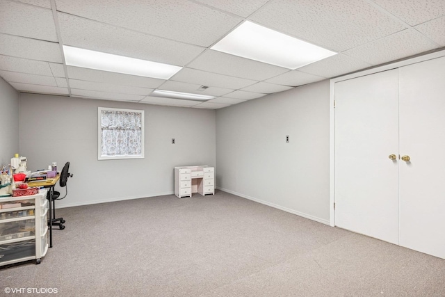 carpeted home office featuring a paneled ceiling and baseboards