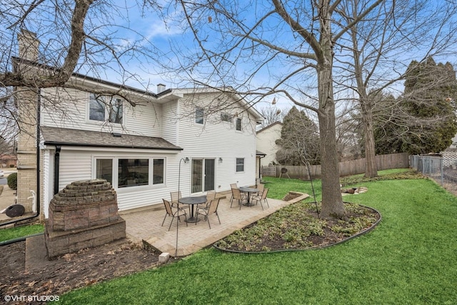 back of property with a patio, a fenced backyard, roof with shingles, a lawn, and a chimney