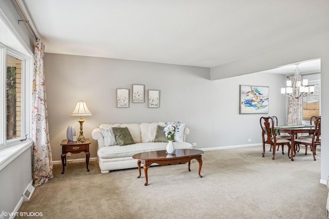 living area with an inviting chandelier, baseboards, visible vents, and carpet flooring