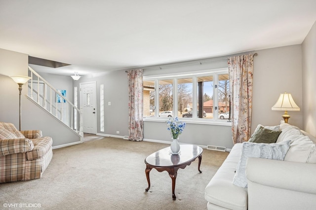 carpeted living room with stairs, visible vents, and baseboards