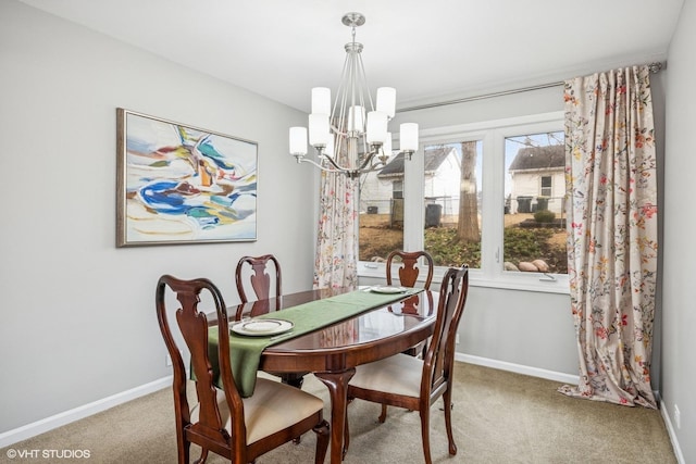 carpeted dining space with baseboards and an inviting chandelier