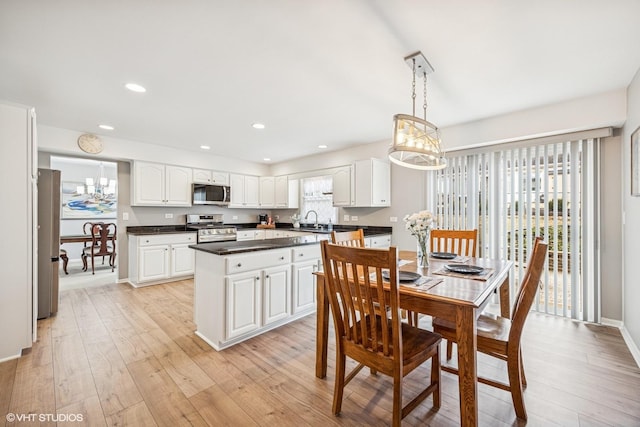 dining room featuring baseboards, recessed lighting, an inviting chandelier, and light wood-style floors