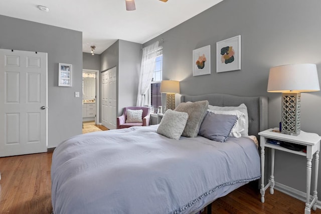 bedroom featuring ceiling fan, connected bathroom, wood finished floors, baseboards, and a closet