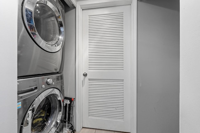 washroom with stacked washer and clothes dryer and laundry area