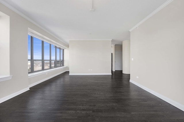 empty room with baseboards, dark wood-style flooring, and crown molding