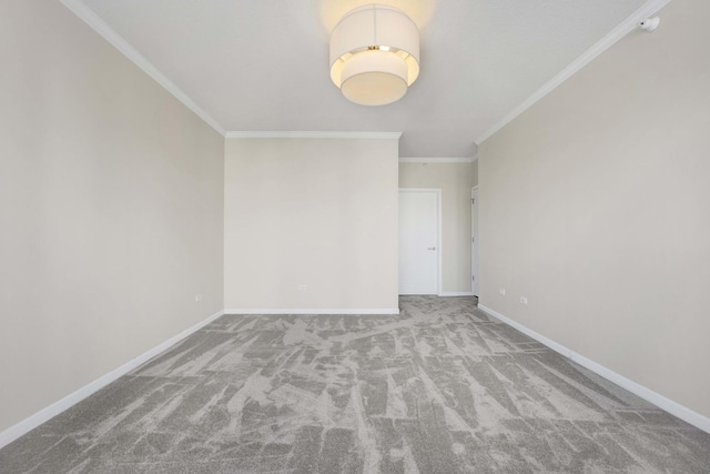 carpeted spare room featuring ornamental molding and baseboards