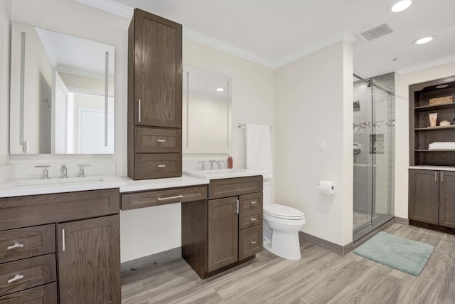 bathroom with ornamental molding, a stall shower, double vanity, and wood finished floors